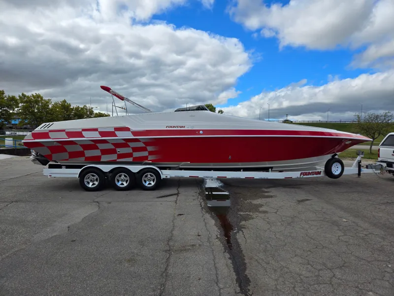 Slide: The Image of 1995 Fountain 38 Sport Cruiser boat with red and white design on a trailer. - 6
