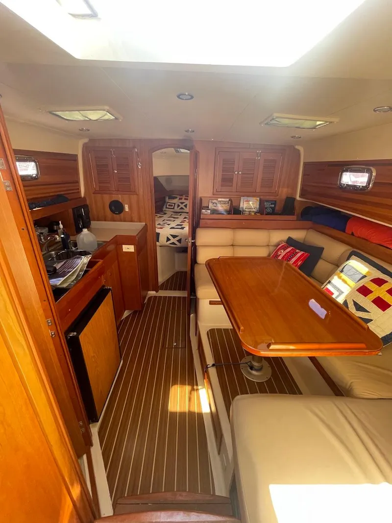 Slide: The Image of 2003 Mainship Pilot 34 galley with wooden cabinetry, microwave, and storage shelves. - 20