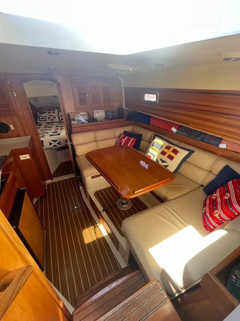 Slide: The Image of 2003 Mainship Pilot 34 galley with wooden shelves, plates, and storage jars. - 21