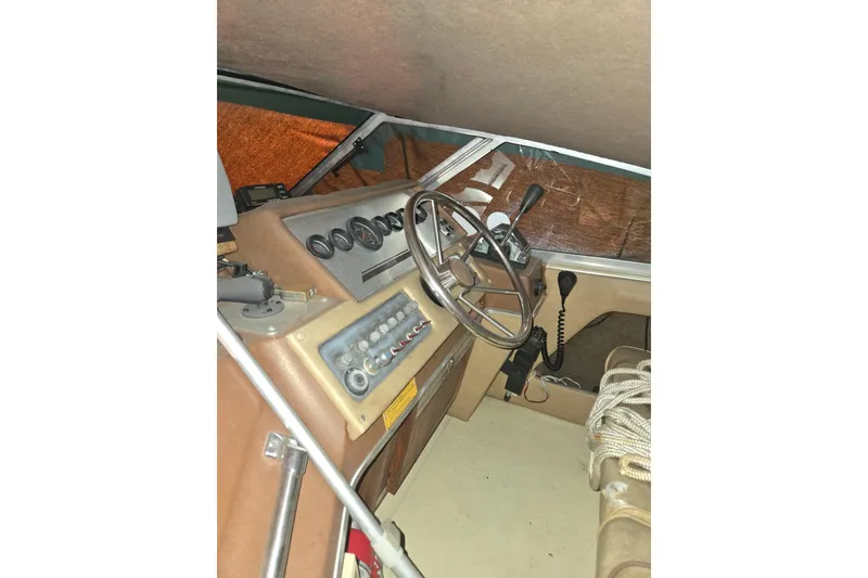 Slide: The Image of 1983 Sea Ray Weekender boat cockpit with steering wheel, gauges, and control panel. - 14