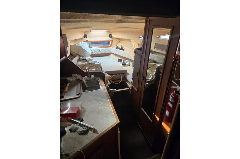 Slide: The Image of Interior of a 1983 Sea Ray Weekender boat with kitchenette and seating area. - 3