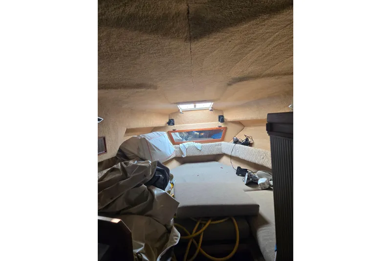 Slide: The Image of Interior cabin of a 1983 Sea Ray Weekender boat, featuring seating and storage. - 5