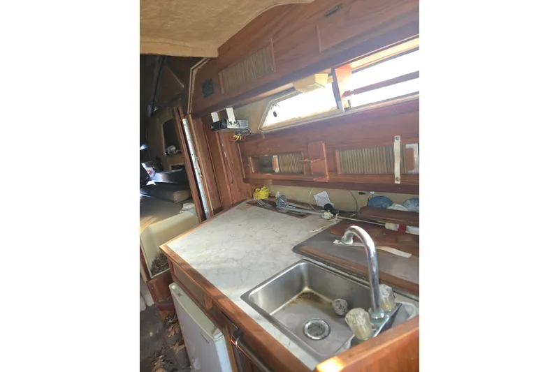 Slide: The Image of 1983 Sea Ray Weekender boat interior with wooden cabinetry and compact kitchen area. - 6