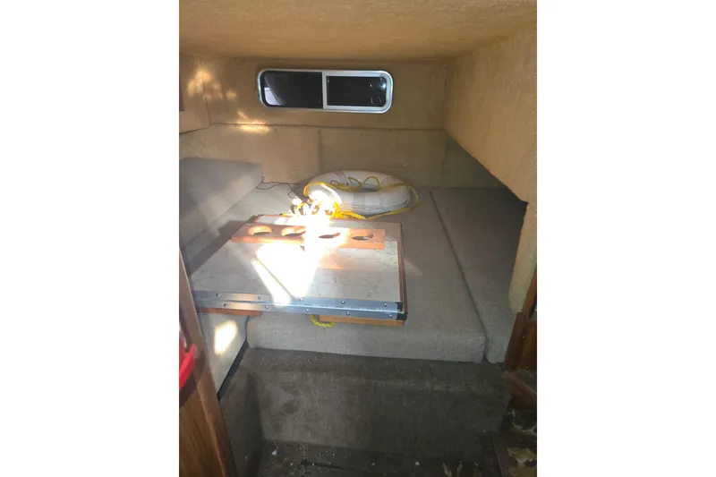 Slide: The Image of Interior cabin of 1983 Sea Ray Weekender boat with cushions and window. - 7