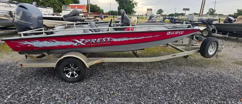 Slide: The Image of 2016 Xpress Xclusive Series X18 boat on trailer, red and silver design, parked on gravel. - 4