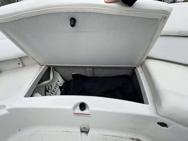 Slide: The Image of Open storage compartment on a 2015 Monterey 224FS boat, showing interior contents. - 11