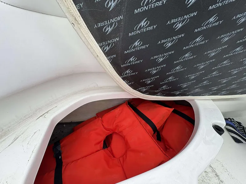 Slide: The Image of 2015 Monterey 224FS boat storage with orange life jacket and branded cover. - 13