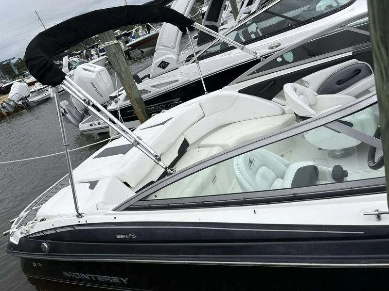 Slide: The Image of 2015 Monterey 224FS boat docked, featuring sleek design and white interior. - 2