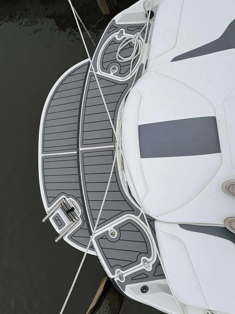 Slide: The Image of 2015 Monterey 224FS boat deck with gray and white seating, docked by water. - 5