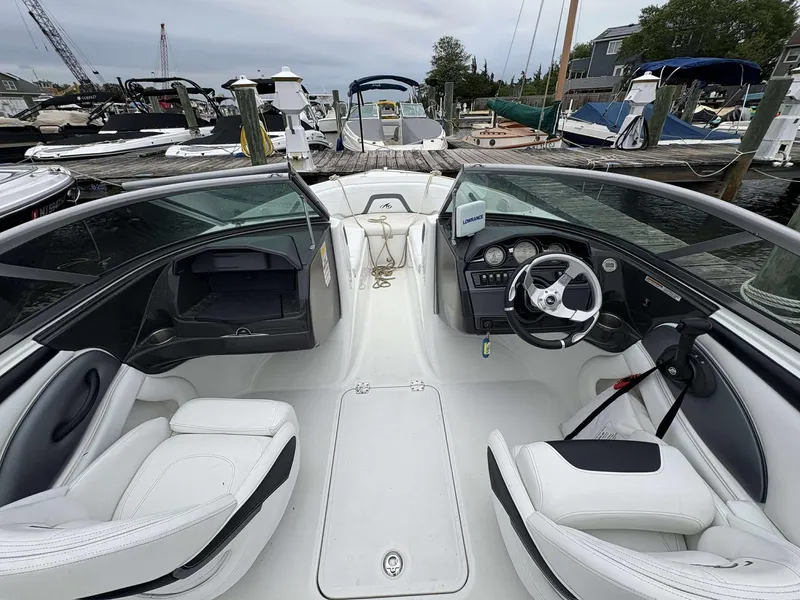Slide: The Image of 2015 Monterey 224FS boat interior at a marina, featuring white seating and steering console. - 6