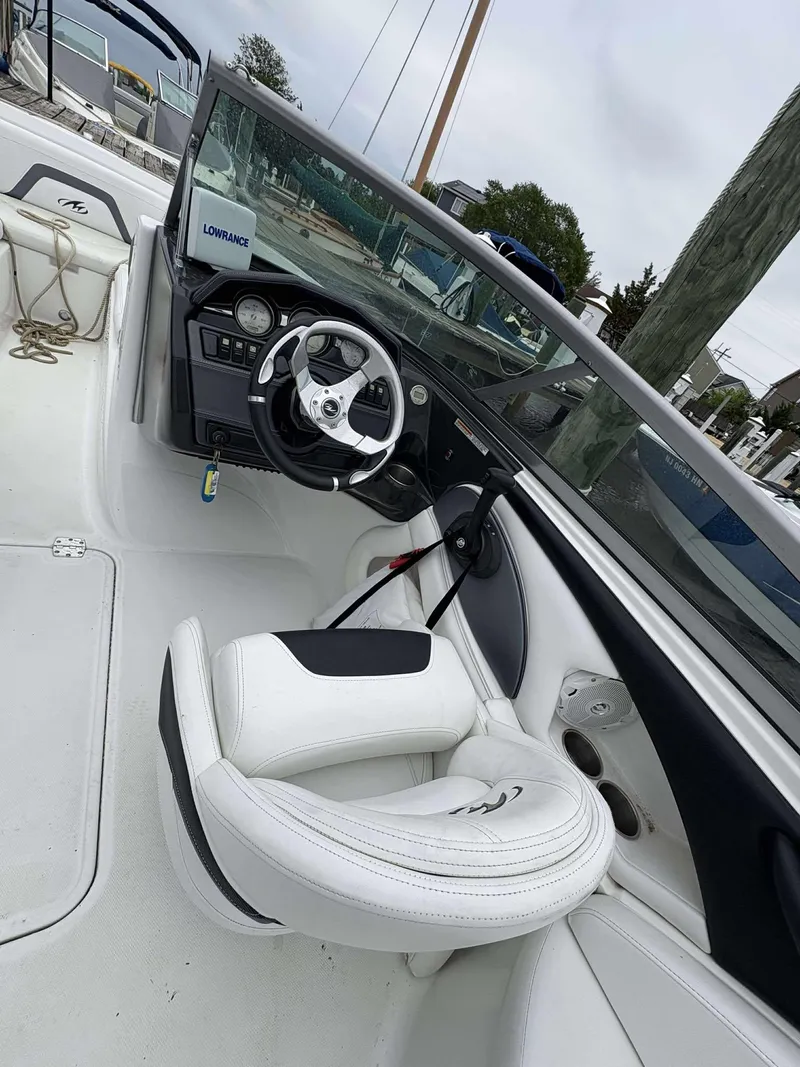 Slide: The Image of 2015 Monterey 224FS boat interior with steering wheel and white seating. - 7