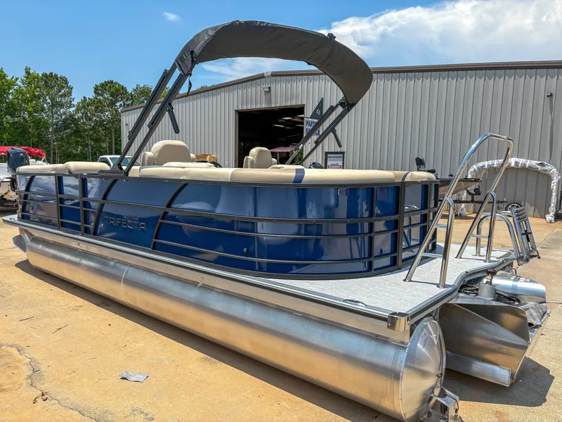 Slide: The Image of 2025 Trifecta CS 24RF 3.0 pontoon boat with blue exterior and canopy, parked outdoors. - 1