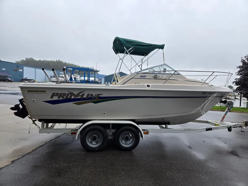 Slide: The Image of 1997 Pro-Line 201 Walkaround boat on trailer, parked outdoors on a rainy day. - 10