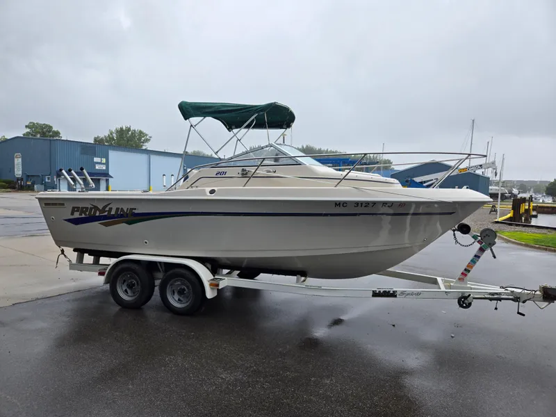 Slide: The Image of 1997 Pro-Line 201 Walkaround boat on trailer, parked outdoors on a rainy day. - 11