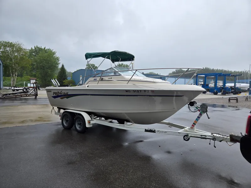 Slide: The Image of 1997 Pro-Line 201 Walkaround boat on trailer, parked outdoors on a rainy day. - 12