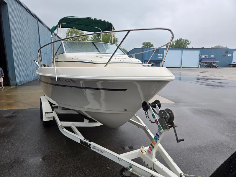 Slide: The Image of 1997 Pro-Line 201 Walkaround boat on trailer, parked outside industrial building. - 14