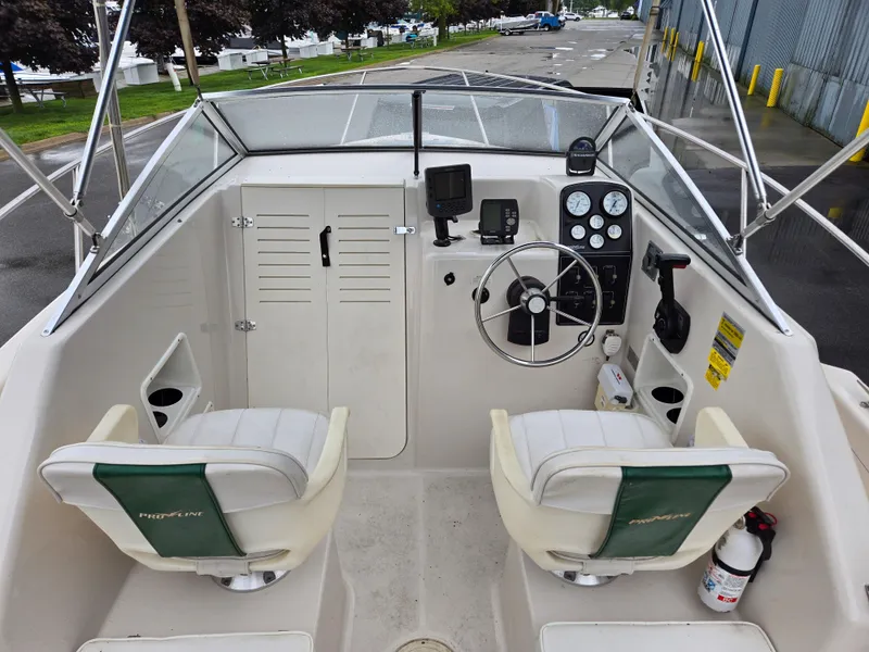 Slide: The Image of 1997 Pro-Line 201 Walkaround boat interior with steering wheel and seating. - 17