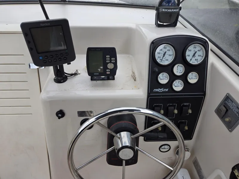 Slide: The Image of 1997 Pro-Line 201 Walkaround boat dashboard with steering wheel and gauges. - 20