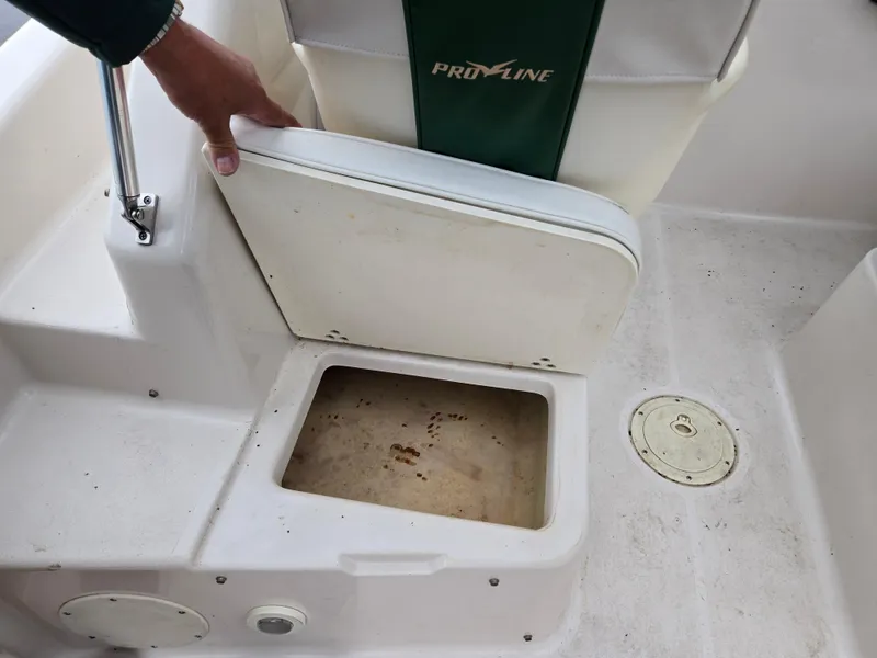Slide: The Image of 1997 Pro-Line 201 Walkaround boat seat storage compartment open. - 27