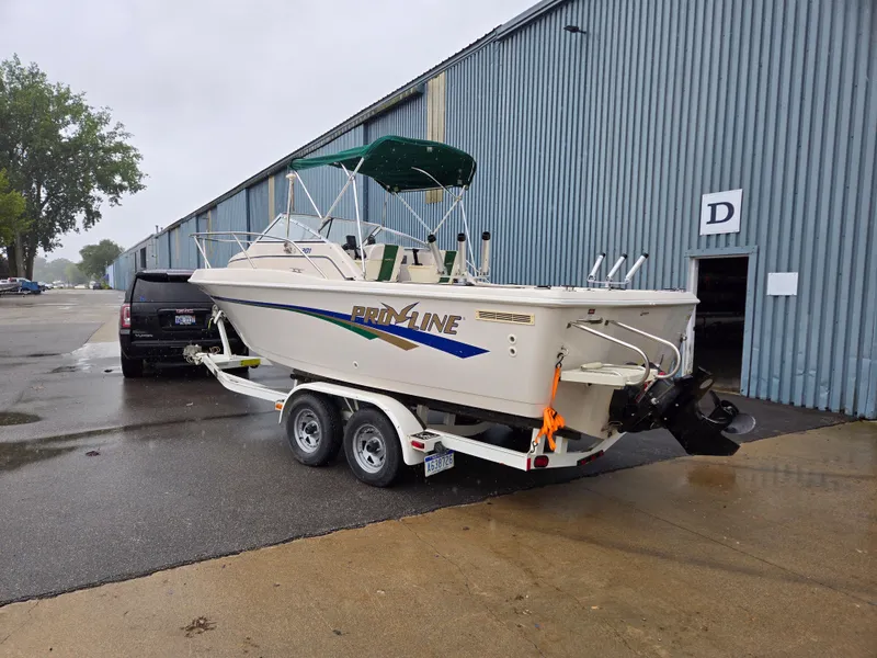 Slide: The Image of 1997 Pro-Line 201 Walkaround boat on trailer near industrial building. - 3