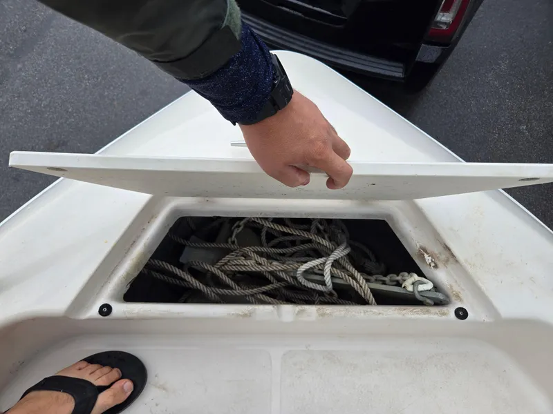 Slide: The Image of 1997 Pro-Line 201 Walkaround boat storage compartment with ropes and anchor. - 46