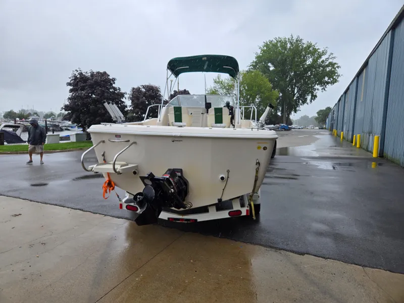 Slide: The Image of 1997 Pro-Line 201 Walkaround boat on trailer in rainy marina setting. - 6