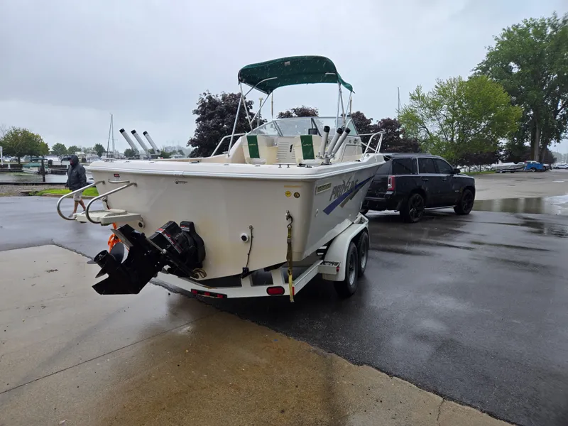 Slide: The Image of 1997 Pro-Line 201 Walkaround boat on trailer, parked on wet pavement. - 7
