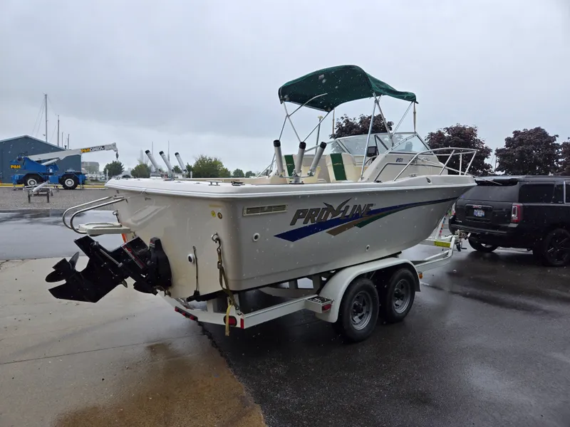 Slide: The Image of 1997 Pro-Line 201 Walkaround boat on trailer, parked outdoors on a rainy day. - 8