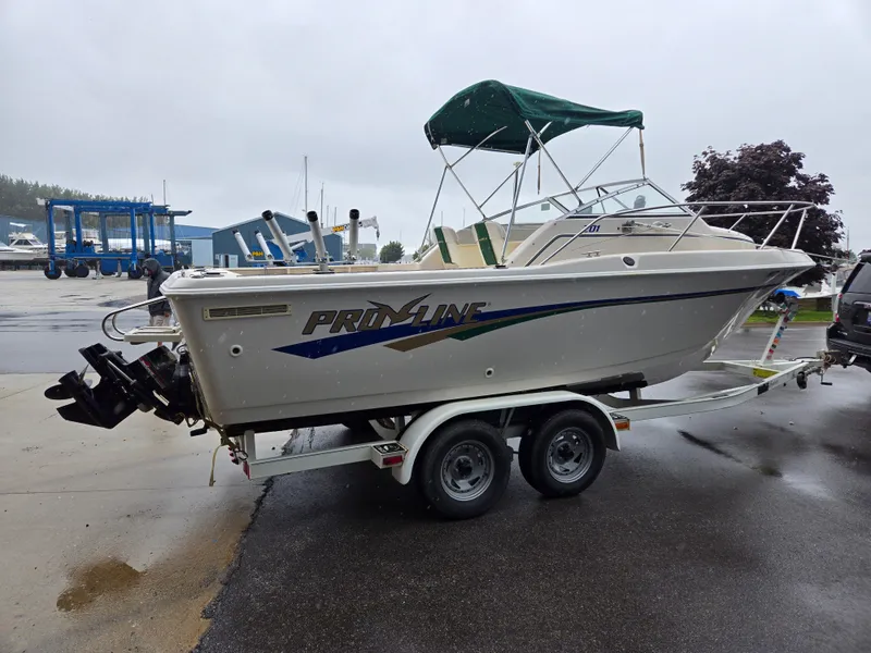 Slide: The Image of 1997 Pro-Line 201 Walkaround boat on trailer, parked in marina. - 9