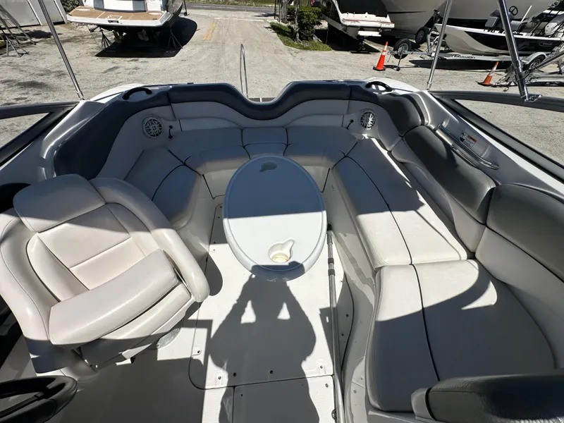 Slide: The Image of 2011 Yamaha Boats SX210 interior with seating and table, docked outdoors. - 26