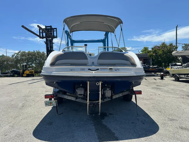 Slide: The Image of 2011 Yamaha Boats SX210, rear view, parked on a trailer under a clear blue sky. - 4