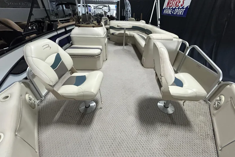 Slide: The Image of 2005 Bennington II 227FSi pontoon boat interior with beige seating and steering console. - 6
