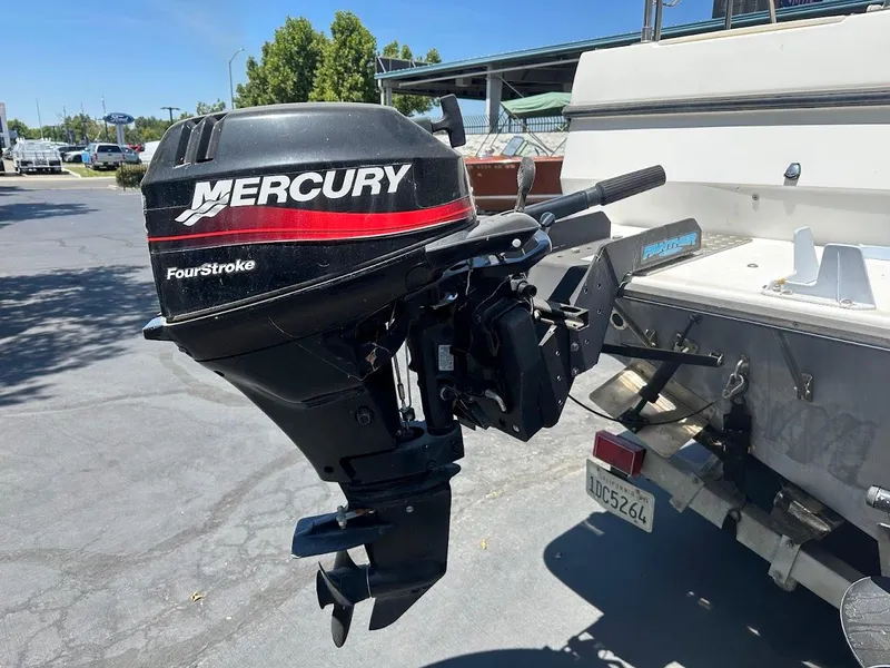 Slide: The Image of 1992 Bayliner 2359 Trophy with Mercury FourStroke outboard motor in a parking lot. - 12