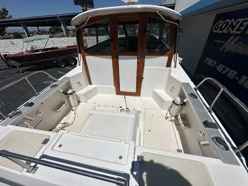 Slide: The Image of 1992 Bayliner 2359 Trophy boat deck with wooden cabin doors and fishing equipment. - 13