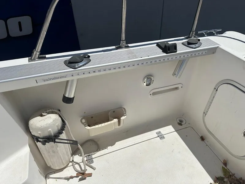 Slide: The Image of Interior view of a 1992 Bayliner 2359 Trophy boat, featuring fishing rod holders and a measuring ruler. - 16