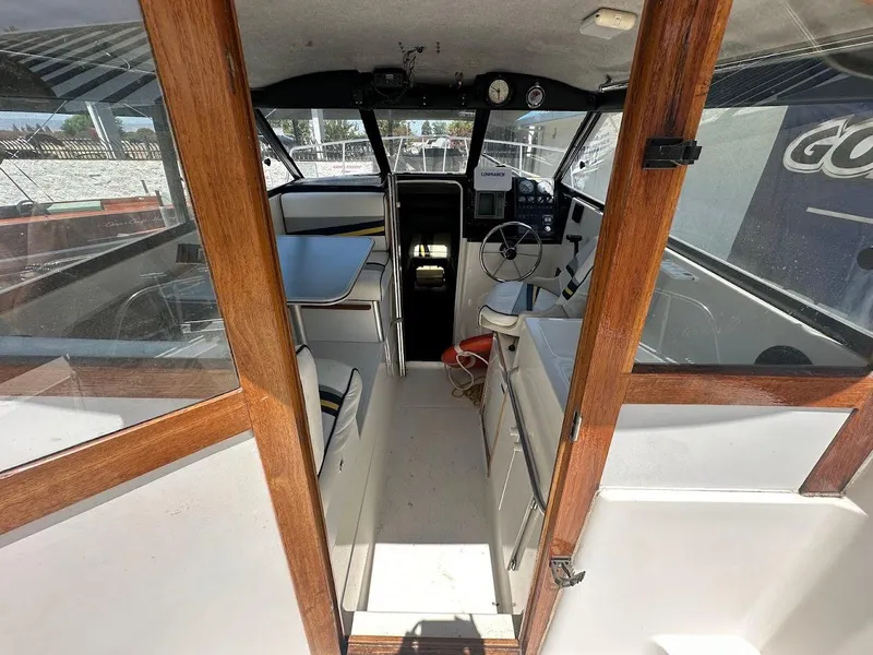 Slide: The Image of Interior view of a 1992 Bayliner 2359 Trophy boat, featuring wooden accents and steering area. - 19