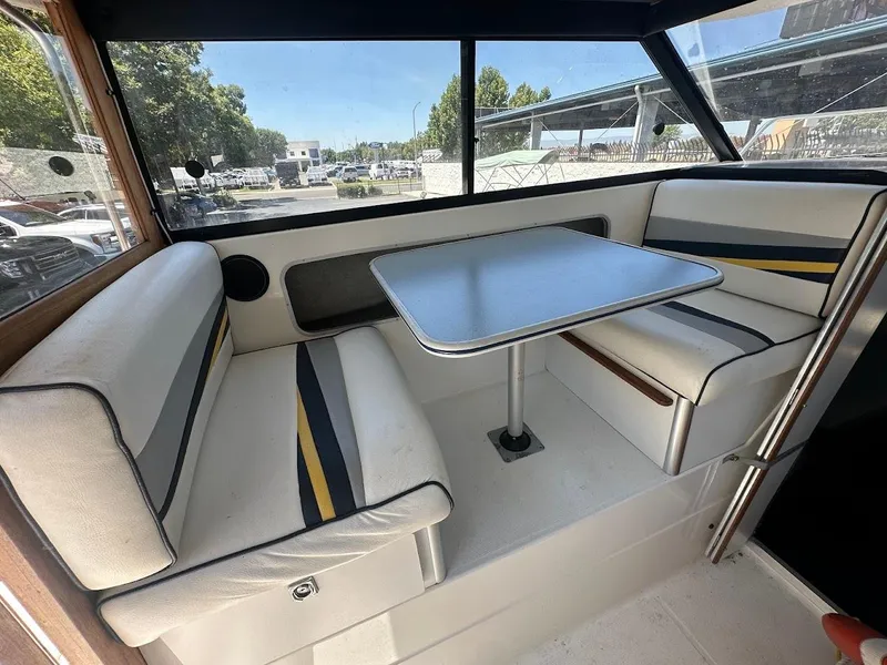 Slide: The Image of Interior of a 1992 Bayliner 2359 Trophy boat with cushioned seating and table. - 21