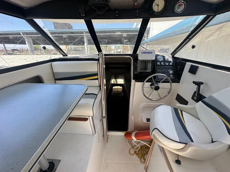 Slide: The Image of Interior of 1992 Bayliner 2359 Trophy boat with steering wheel and seating area. - 22