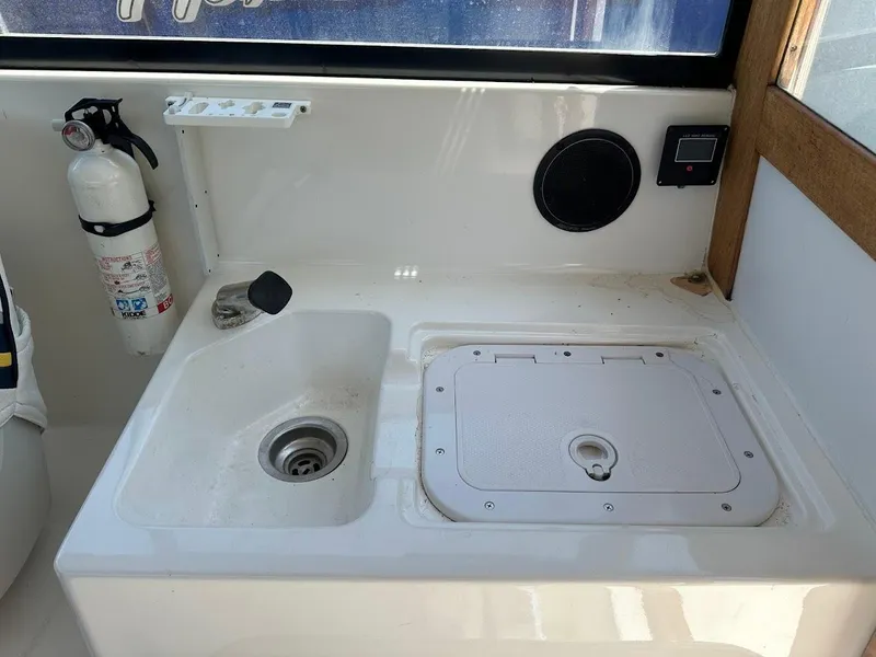 Slide: The Image of Interior of 1992 Bayliner 2359 Trophy boat with sink, fire extinguisher, and storage compartment. - 24