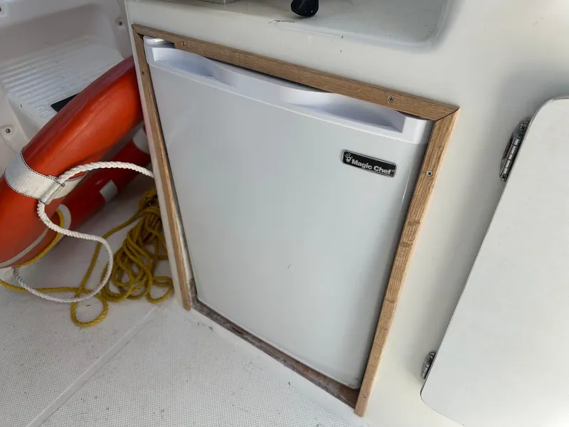 Slide: The Image of Magic Chef fridge on 1992 Bayliner 2359 Trophy boat with life preserver and rope nearby. - 26