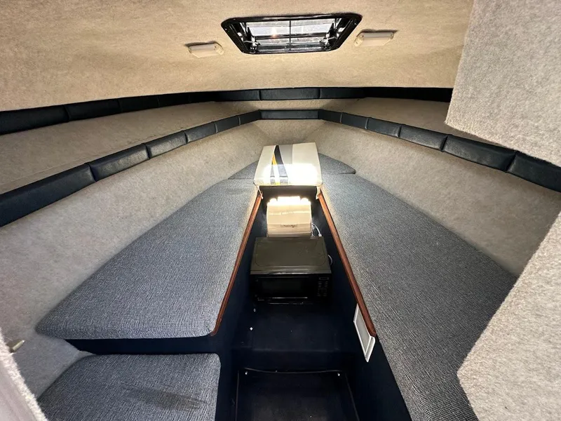 Slide: The Image of Interior cabin of 1992 Bayliner 2359 Trophy boat, featuring seating and storage. - 32