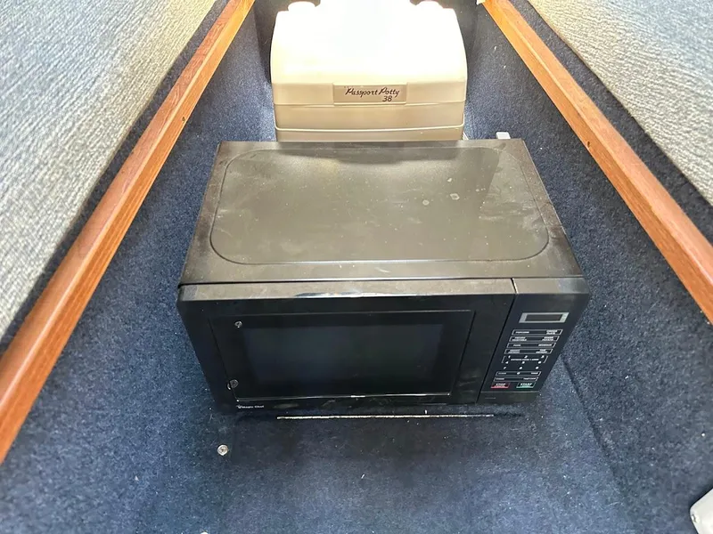 Slide: The Image of Microwave and portable toilet inside 1992 Bayliner 2359 Trophy boat cabin. - 33