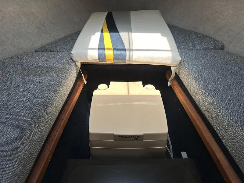 Slide: The Image of Interior of 1992 Bayliner 2359 Trophy boat with portable toilet and cushioned seating. - 34