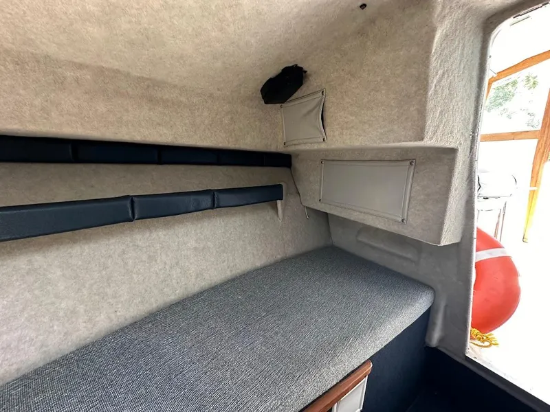 Slide: The Image of 1992 Bayliner 2359 Trophy cabin interior with cushioned seating and storage compartments. - 35