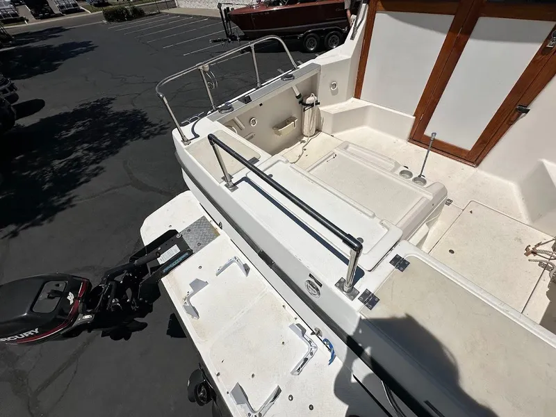 Slide: The Image of 1992 Bayliner 2359 Trophy boat deck with Mercury outboard motor, parked in a lot. - 38