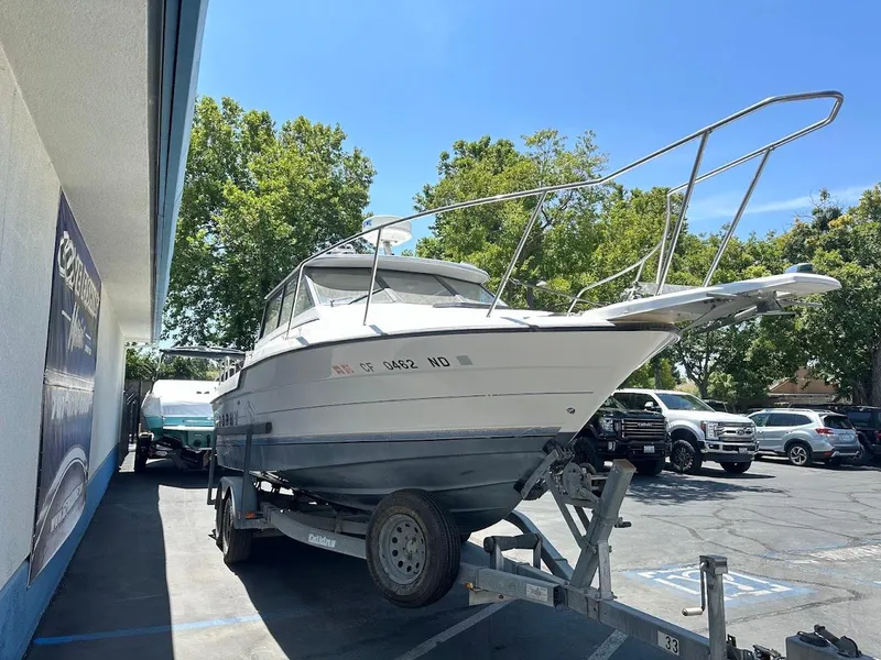 Slide: The Image of 1992 Bayliner 2359 Trophy boat on trailer in parking lot, sunny day. - 4