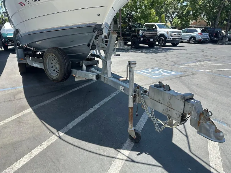 Slide: The Image of 1992 Bayliner 2359 Trophy boat on trailer in parking lot, sunny day. - 5