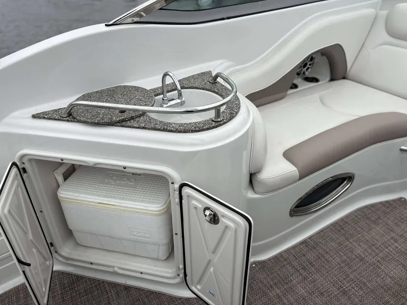 Slide: The Image of 2018 Crownline 264 CR boat interior with sink, seating, and storage compartment. - 11