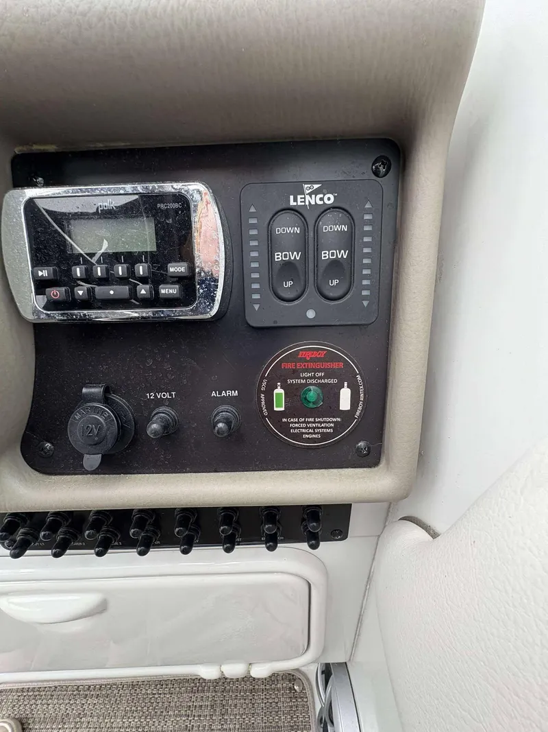 Slide: The Image of Control panel of a 2018 Crownline 264 CR boat with Lenco trim tab switches. - 13