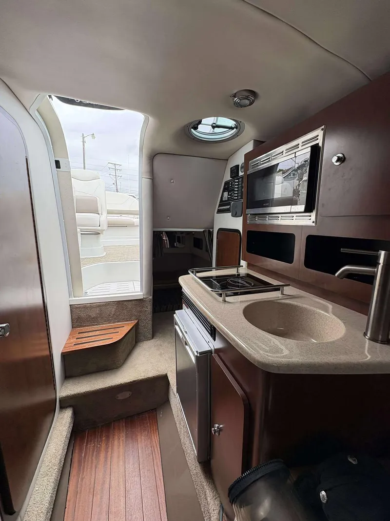 Slide: The Image of 2018 Crownline 264 CR cabin interior with kitchenette, microwave, and sink. - 18